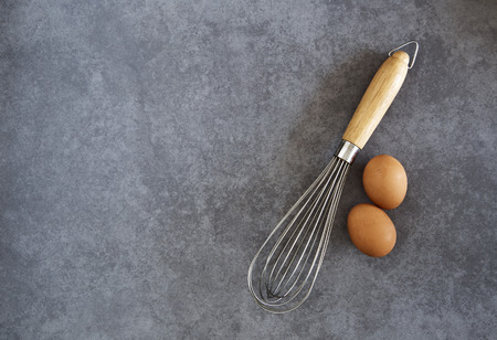 Kitchen Wire Whisk Eggs Beater on the wood tableの写真素材