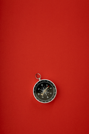 Direction concept with compass on red background top view mockupの写真素材