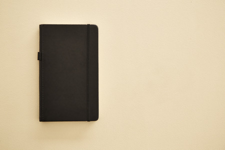 Business office accessory note book with pen on table leather background