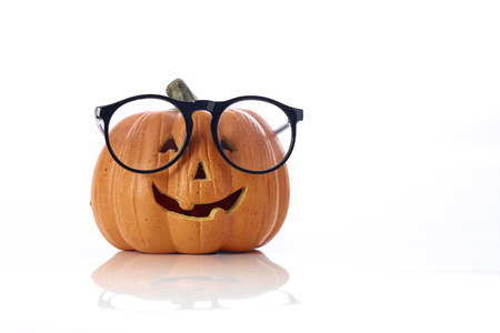 Carved smiling pumpkin Jack-o'-lantern with spectacles
on white background, Halloweenの写真素材