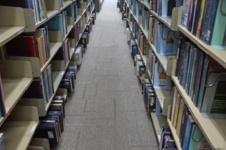 Blurred bookshelf in the library room, education background, back to school conceptの写真素材