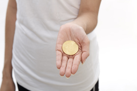 Close up of Bitcoin in hand for cryptocurrency concept on white backgroundの写真素材