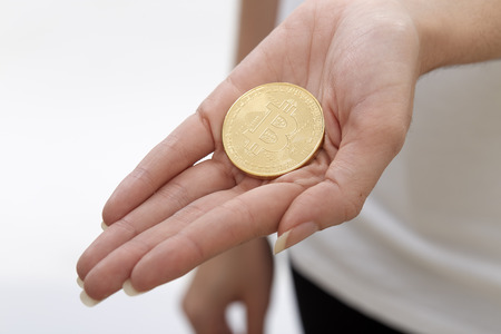 Close up of Bitcoin in hand for cryptocurrency concept on white backgroundの写真素材