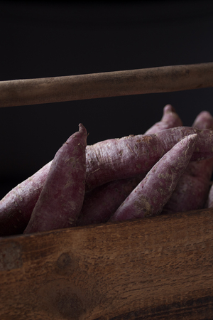 Purple Sweet potatoes in wooden box rustic tableの写真素材