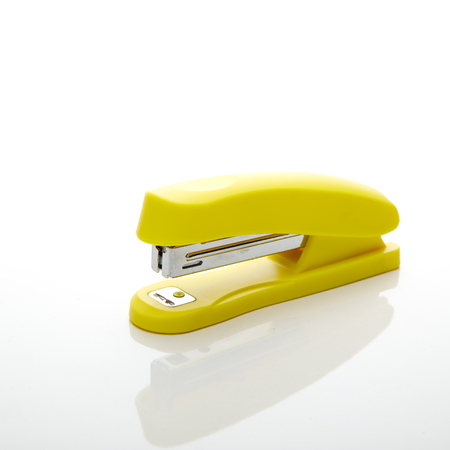 Yellow stapler on the white background for text copy space - office stationaryの写真素材