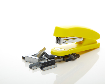 Yellow stapler on the white background for text copy space - office stationary