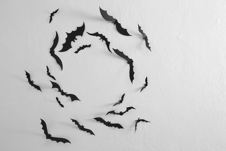 Halloween Black paper bats flying over wall white background, Decoration Concept Free space as you design, natural lightの写真素材