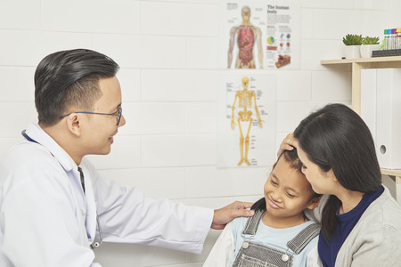 Asian man doctor examination to young child and mother Prevention and Health Care Concepts, Basic Medical Care in Asiaの写真素材