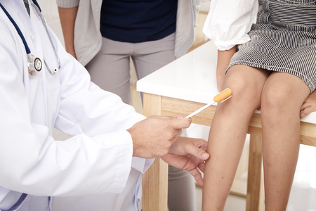 A male doctor happily describes his son's health in the clinic.