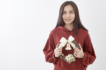 Portrait of beauty young woman with christmas wreath and gift on white wall  backgroundの写真素材