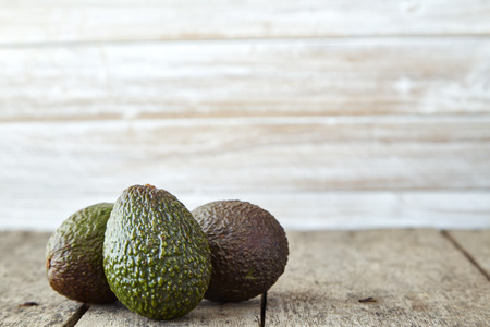 Avocado on old wooden table. Fruits healthy food concept. empty space. Natural morning sunshine on the left side.の写真素材