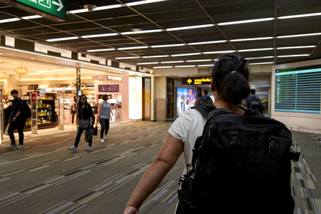 Asia Woman use mobile phone and blurred image of people wait in the airport boarding gate, World...