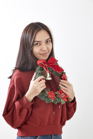 Asian  beauty young woman with christmas wreath and gift on white wall  backgroundの写真素材