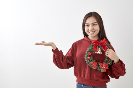 Asian  beauty young woman with christmas wreath and gift on white wall  backgroundの写真素材