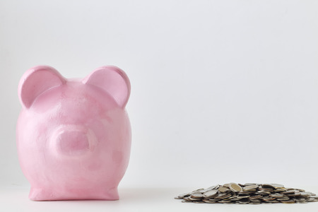 Pink piggy bank and coins on white background. Finance, saving money, In the natural stateの写真素材