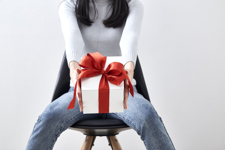 Beautiful sexy young Asian woman gift box sitting in a chair on white background, Picture includes copy spaceの写真素材
