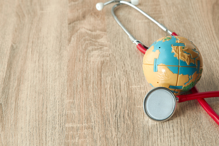 World Earth Day April 22, 2019 and World health day, April 7 concept. earth with red Stethoscope on wooden table background texture. Empty space for design,Soft sunlightの写真素材