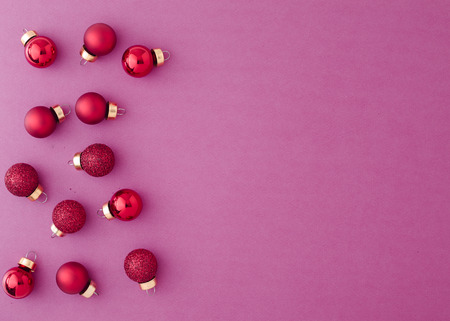 Red Ornament Christmas Balls on Pastel Purple Paper background with New Year Christmas presents Xmas...