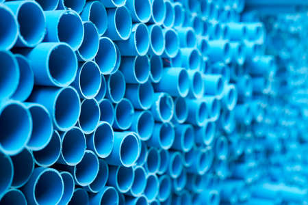 background of colorful  Blue PVC pipes stacked in construction siteの写真素材