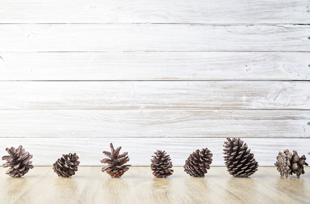 Christmas frame pine cones with wall white woodenの写真素材