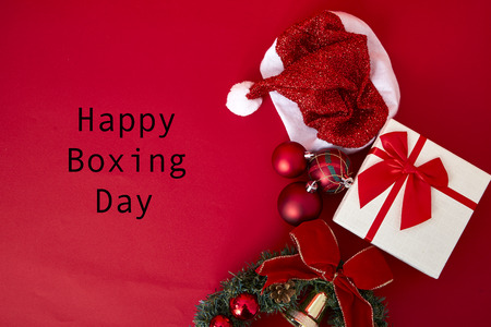 Shopping with gift boxes and branches of fir-tree with decoration on a redの写真素材