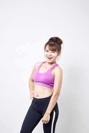 Asian woman wearing sportswear and show her body on white backgroundの写真素材