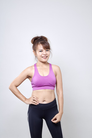 Asian woman wearing sportswear and show her body on white backgroundの写真素材
