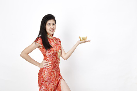 Portrait Beautiful Asian woman Chinese girl hands showing something, in traditional red cheongsam standing on white background, Empty space for design, Business conceptの写真素材