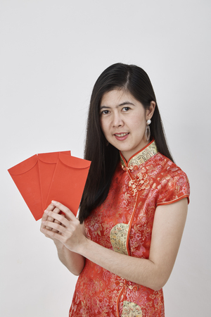 Beauty Chinese woman wear cheongsam and take Red envelopes chinese new year 2019, Concept of happy chinese new yearの写真素材