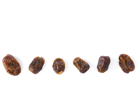 Dried dates (fruits of date palm Phoenix dactylifera) on a white background.の写真素材