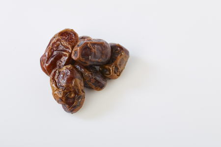 Dried dates (fruits of date palm Phoenix dactylifera) on a white background.の写真素材