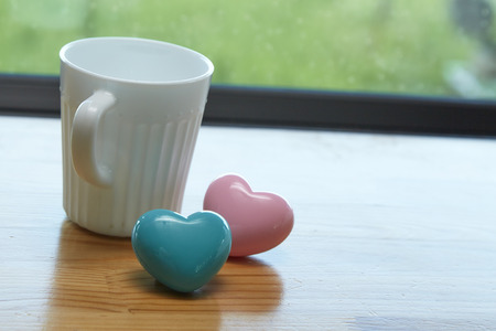 White coffee cup white Pink heart with blue and green background in morning sunlightの写真素材