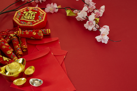Chinese new year 2019 festival decorations.firecrackers,gold ingot,red packet,plum blossom,on red background. Top view accessories. Translation: Fu meaning good fortune, Chun meaning spring.の写真素材