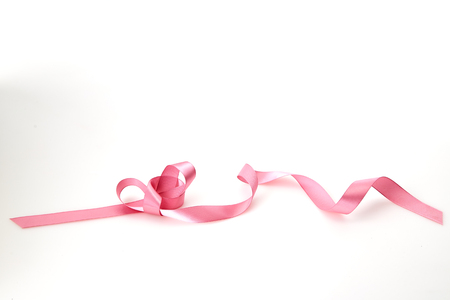 Curled pink ribbon on white background, Empty space for designの写真素材