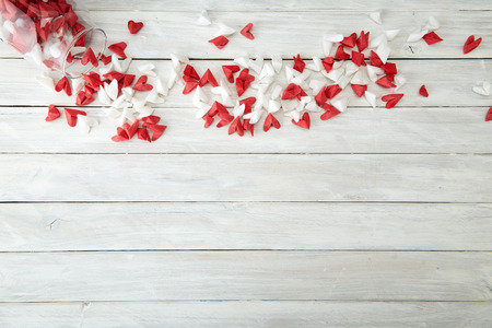 Valentine's Day symbolizing love Red and white origami hearts in Glass bottle white wooden table background, Empty space for simple designの写真素材