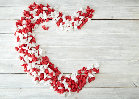 Gift Heart shape, white and red folded paper on a white wooden table with empty space for text, Valentine Day and Mother's Day conceptの写真素材