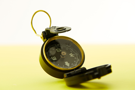 Close up Minimal Compass on bright yellow background , Concept of Travel above with copy space.の写真素材
