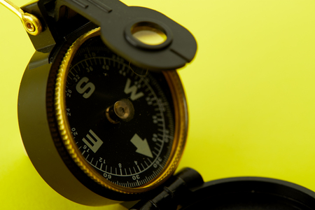 Close up Minimal Compass on bright yellow background , Concept of Travel above with copy space.の写真素材