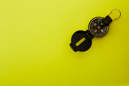 Close up Minimal Compass on bright yellow background , Concept of Travel above with copy space.の写真素材