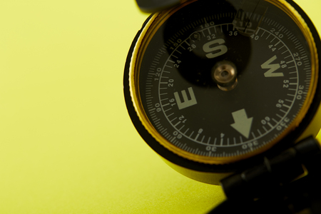 Close up Minimal Compass on bright yellow background , Concept of Travel above with copy space.の写真素材