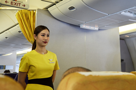 Bangkok Thailand, Jan 22 ,2019 , Airline nokscoot Interior of airplane with passengers on seats and stewardess in Yellow Flight attendant presenting a life vest on board before the flight departureのeditorial素材