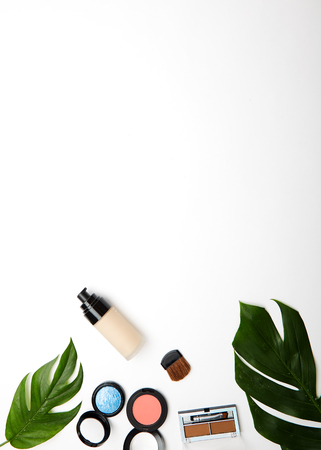 Frame made of tropical leaf, top view of cosmetic makeup products  on white background with copy space, Flat lay, woman blog mockup. summer travel concept.の写真素材