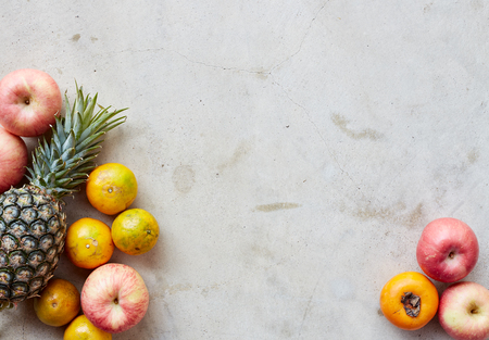 Organic fresh fruits frame on a gray concrete background, clean eating concept. Top view, copy spaceの写真素材