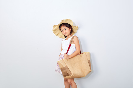 Summer Shopping little girl holding bag on white studio background, Fashion, sale, shopping concept, big saleの写真素材