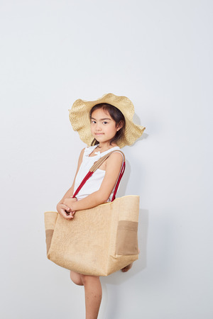 Summer Shopping little girl holding bag on white studio background, Fashion, sale, shopping concept, big saleの写真素材