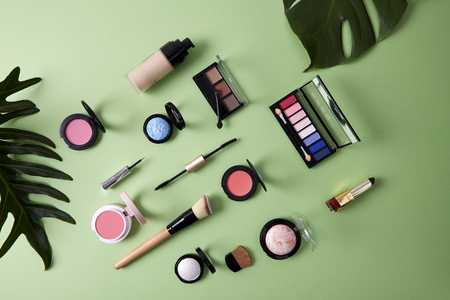 Spring Flat lay composition with skin foundation, powder and beauty accessories, Cosmetic beauty products arranged on a paper green pastelの写真素材