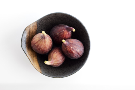 Organic figs in a bowl on white table backgroundの写真素材
