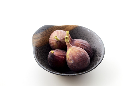 Organic figs in a bowl on white table backgroundの写真素材