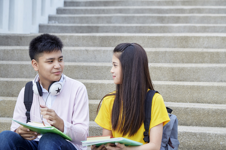 Two students guy and girl studying stairs in park of happy teen high school students outdoorsの写真素材