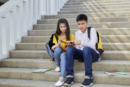 Two students guy and girl studying stairs in park of happy teen high school students outdoorsの写真素材
